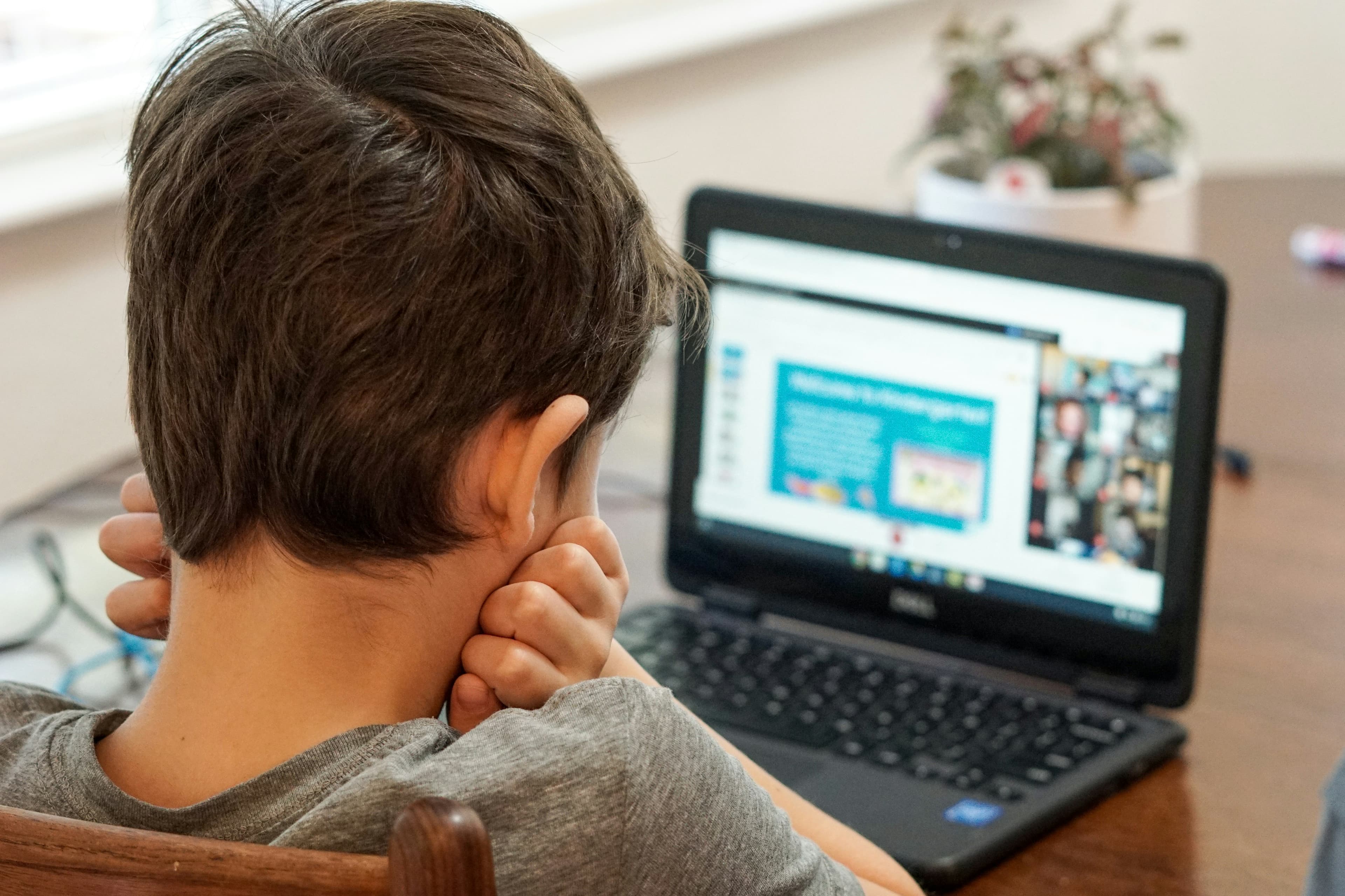 A child working through a problem at a laptop